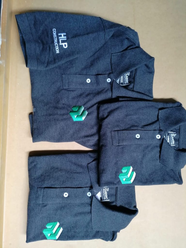 Folded navy workwear with green embroidered logos