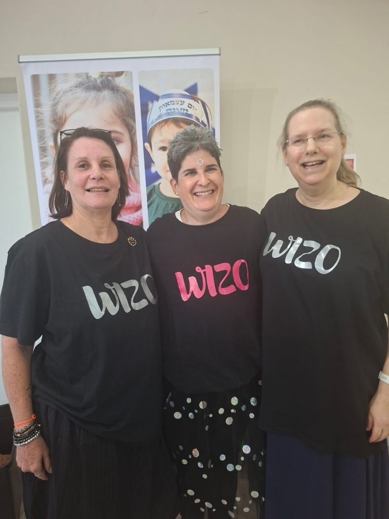 Three people wearing coordinated black branded T-shirts