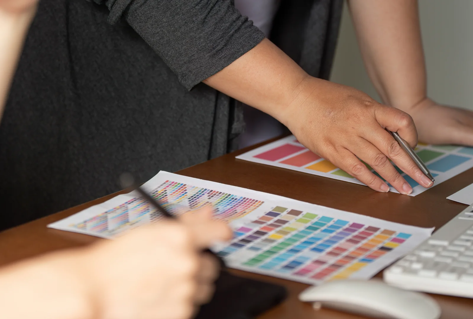 Design team reviewing printed colour charts and selecting a palette together