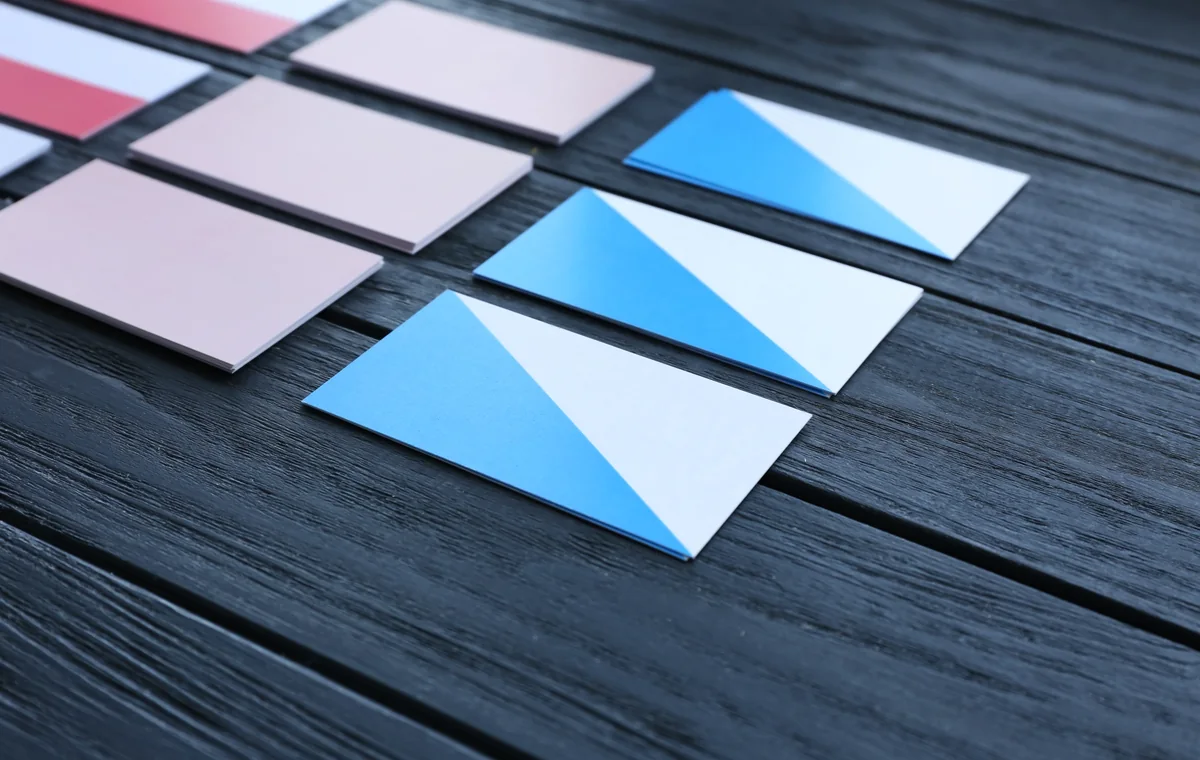 Finished business cards arranged on a dark wooden print table